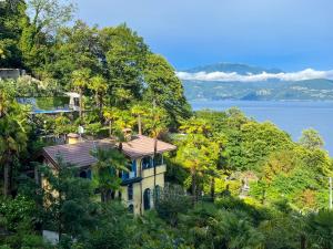 a house on a hill next to the water at Villa Zanotti in Cannero Riviera