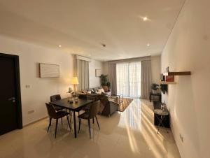 a dining room and living room with a table and chairs at Thewalk2 Pool View ~ 5 mins from Airport in Seeb
