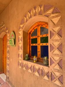 a window of a house with vases on a window sill at Dar Dallali maison d'hôtes et excursions in Mhamid
