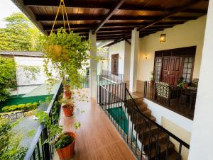 a hallway of a house with potted plants at Eighty seven guest and restaurant in Badulla