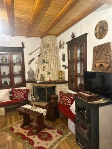 a living room with a tv and a couch and a table at Guest House Iljesa in Berat