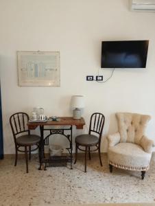 a dining room with a table and chairs and a tv at Le stanze di Bruno in Pescara