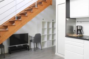 a living room with a table and a television and a staircase at Stunning Bright Duplex in Saint-Ouen