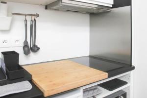 a kitchen with a wooden cutting board on a counter at Stunning Bright Duplex in Saint-Ouen