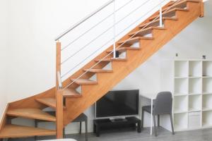 a staircase in a home with a desk and a tv at Stunning Bright Duplex in Saint-Ouen +46 photos