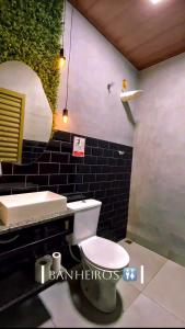 a bathroom with a white toilet and a sink at Ks Espaço in Rondonópolis