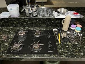 a stove top on a kitchen counter with utensils at Ks Espaço in Rondonópolis
