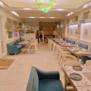 a restaurant with tables and chairs and people in the background at Hotel Samrat - A Boutique Hotel in Prayagraj