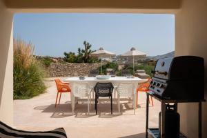 a patio with a table and chairs and a grill at Parasporos Villa - Private Pool - Beach Access in Parasporos