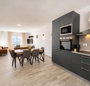 a kitchen and living room with a table and chairs at 3-bedroom Sea View Home with Private Parking in Mokošica