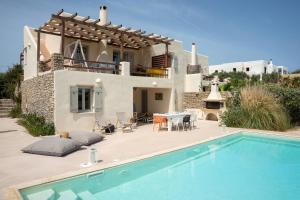 a villa with a swimming pool in front of a house at Parasporos Villa - Private Pool - Beach Access in Parasporos