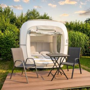 a bed on a boat with two chairs and a table at Cubes am Irrsee - SELF CHECK-IN in Sommerholz