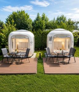 an rv with two tables and chairs in the grass at Cubes am Irrsee - SELF CHECK-IN in Sommerholz