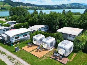 an aerial view of a group of rvs parked in a field at Cubes am Irrsee - SELF CHECK-IN in Sommerholz +2 photos