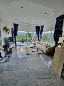 a living room with a couch and a table at Keya Mountain View Pool Villa Samui in Ban Thung