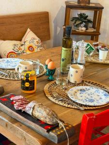 a wooden table with plates and eggs and a bottle of wine at Agriturismo Fruske in Aurisina