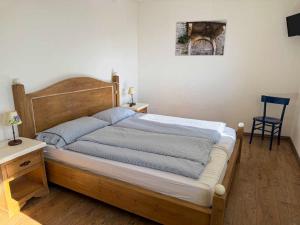 a bedroom with a large bed with a wooden headboard at Agriturismo Fruske in Aurisina +7 photos