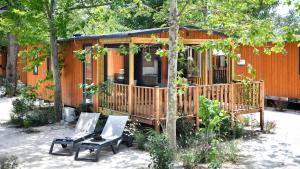 a cabin with two chairs in front of it at Vic's Land Holidays in Grimaud