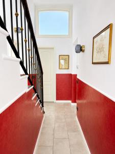 a hallway with red and white walls and stairs at Rainbow District Mood Villa in Milan
