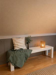 a white bench with a pillow and a vase on it at Green Door Loft Stilvolles 160 m2 Apartment Balkon Gartenblick Workstation Hundefreundlich in Ibbenbüren +33 photos