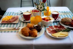 a table topped with plates of breakfast foods and drinks at Hotel Palacio Alcázar in Seville