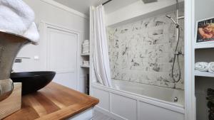 a bathroom with a walk in shower and a sink at Appartement in Craon
