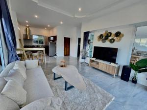 a living room with a couch and a tv at Keya Mountain View Pool Villa Samui in Ban Thung
