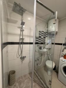 a bathroom with a shower with a toilet and a sink at Hide Avenue Dedinje in Dedinje
