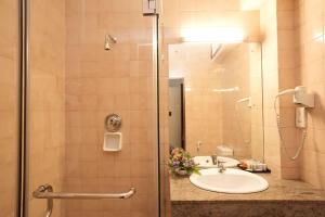 ein Badezimmer mit Waschbecken und Dusche in der Unterkunft Hotel Casamara - Center Point Kandy in Kandy