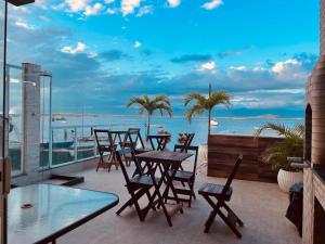 a patio with tables and chairs and a view of the ocean at Escondidinho Bar, hostel e casa de festas in Rio de Janeiro