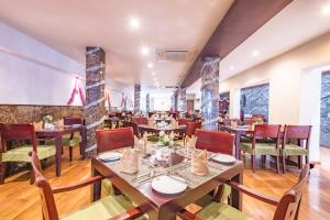 ein Restaurant mit Tischen und Stühlen in einem Raum in der Unterkunft Hotel Casamara - Center Point Kandy in Kandy