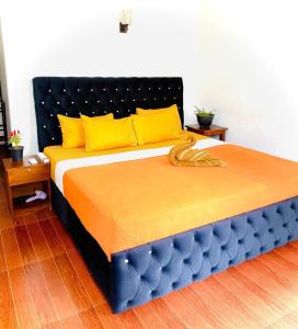 a large bed with yellow and blue pillows in a room at Ceylan Crest in Ella
