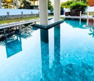 an infinity pool with blue water and white columns at Airport Luxury Villa 65 - Negombo-Airport Transit Guest in Negombo