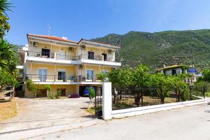 ein großes gelbes Haus mit einem weißen Zaun in der Unterkunft Davis Studios & Apartments - Ήλια Βόρειας Εύβοιας - 1' από τη θάλασσα in Region Ilia