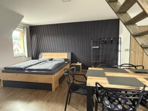 a bedroom with a bed and a table and chairs at Apartmány u Anety in Mladé Buky