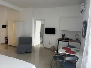 a room with a bed and a table and chairs at La Marina Rooms HOWME in Torre a Mare