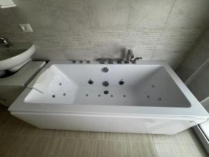 a white bath tub in a bathroom with a toilet at La Marina Rooms HOWME in Torre a Mare