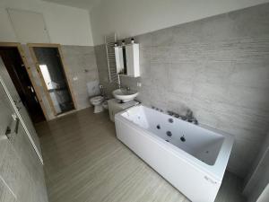 a bathroom with a white tub and a toilet at La Marina Rooms HOWME in Torre a Mare