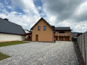 a house with a stone driveway in front of a house at Apartmány u Anety in Mladé Buky +11 photos