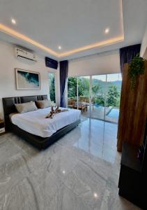 a bedroom with a large bed and a large window at Keya Mountain View Pool Villa Samui in Ban Thung +12 photos