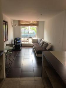 a living room with a couch and a window at Conjunto Buganviles - in Girardot