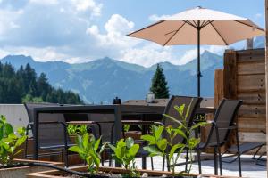 a patio with a table and chairs and an umbrella at Lodge 53 in Breitenwang