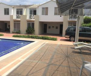 una villa con un coche estacionado junto a una piscina en Conjunto Buganviles -, en Girardot