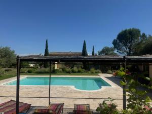 a swimming pool in a yard with chairs and a house at Au Clair Ventoux in Saint-Didier