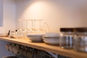 a wooden shelf with wine glasses and bowls on it at El Valle apartment centro Orotava in La Orotava