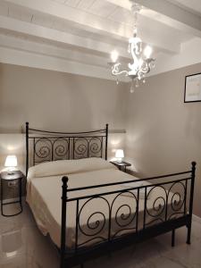 a bedroom with a large bed and a chandelier at Domus Mater in Vigonza