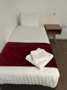 ein Bett mit zwei Handtüchern darauf in der Unterkunft Midland Hotel in Mansfield