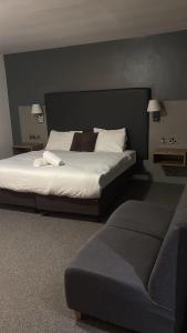 ein Schlafzimmer mit einem großen Bett und einer Couch in der Unterkunft Midland Hotel in Mansfield