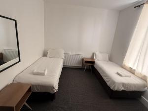 ein kleines Zimmer mit zwei Betten und einem Spiegel in der Unterkunft Midland Hotel in Mansfield