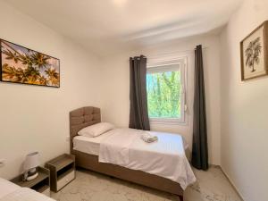 a bedroom with a bed and a window at Captain's Oasis in Budva